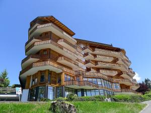 a large wooden building with glass windows at Apartment Le Bristol B52 by Interhome in Villars-sur-Ollon