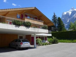 une voiture garée sur un parking devant un immeuble dans l'établissement Apartment Chalet Almisgässli by Interhome, à Grindelwald
