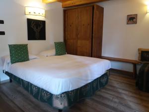 a bedroom with a large bed with two green chairs at Studio Ancienne Bergerie Studio 2 by Interhome in Valtournenche +23 photos