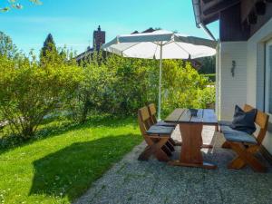 a picnic table and two chairs with an umbrella at Holiday Home Drachenfels in Dittishausen