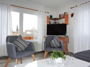 a living room with two chairs and a tv at Holiday Home Drachenfels by Interhome in Dittishausen