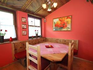 jadalnia z drewnianym stołem i czerwonymi ścianami w obiekcie Apartment Christoph by Interhome w mieście Stumm