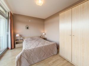 1 dormitorio con 1 cama y un gran armario de madera en Apartment Residentie Astrid-1 by Interhome, en Bredene