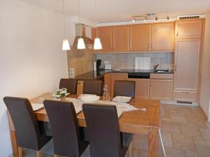 a kitchen with a wooden table with chairs and a dining room at Apartment Grand Panorama C5 by Interhome in Nendaz