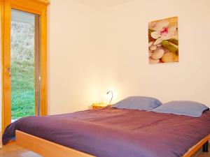 a bedroom with a bed and a window with a picture at Apartment Grand Panorama C5 by Interhome in Nendaz