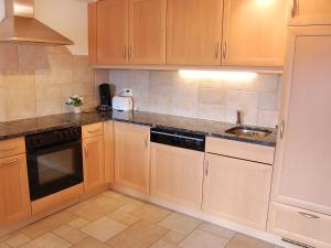 ナンダにあるApartment Grand Panorama C5 by Interhomeの木製のキャビネットとシンクを備えたキッチン