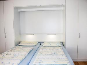 two beds in a room with white cabinets at Apartment Residenza Corallo-16 by Interhome in Ascona