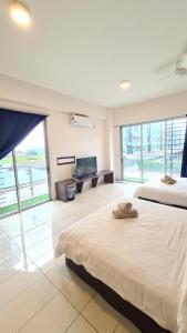 a bedroom with two beds and a flat screen tv at Aeropod KK Corner Unit Near City and Airport 4 pax Free Parking in Kota Kinabalu