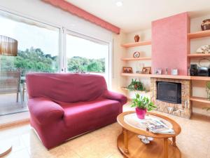 a red chair in a living room with a fireplace at Holiday Home Figaro by Interhome in Blanes