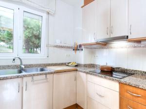 a kitchen with white cabinets and a sink and a window at Holiday Home Figaro by Interhome in Blanes +18 photos
