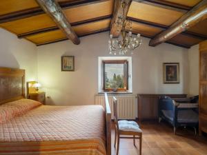a bedroom with a bed and a chair and a chandelier at Holiday Home Capanna by Interhome in San Clemente in Valle