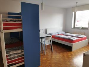 a bedroom with bunk beds and a table and a desk at Dunajska Apartment in Ljubljana