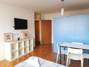 a living room with a table and a tv on a wall at Dunajska Apartment in Ljubljana