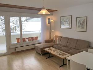 a living room with a couch and a table at Apartment Val Signina-2 by Interhome in Laax-Murschetg