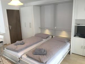 two beds in a small room with a tv at Apartment Val Signina-2 by Interhome in Laax-Murschetg