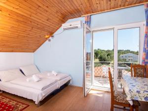 a bedroom with a bed and a balcony at Apartment Balota - Moreška-4 by Interhome in Viganj