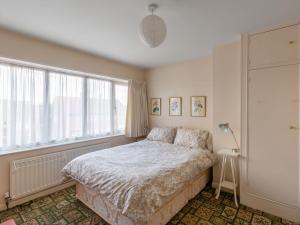 a bedroom with a bed and a large window at Holiday Home Trappers End by Interhome in Whitstable