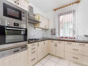 a kitchen with white cabinets and a stove top oven at Holiday Home Yellow 1 by Interhome in Balatonmáriafürdő