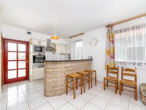eine Küche mit einem Tisch, Stühlen und einer Ziegelwand in der Unterkunft Holiday Home Yellow 1 by Interhome in Balatonmáriafürdő