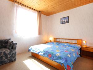 a bedroom with a bed and a window and a chair at Holiday Home Yellow 1 by Interhome in Balatonmáriafürdő +7 photos