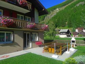 a house with a picnic table and a balcony with flowers at Apartment Amara by Interhome in Saas-Fee