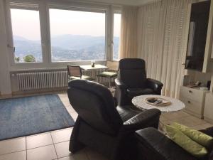 sala de estar con sofá, sillas y ventana grande en Apartment Aldesago Monte Brè - Utoring-31 by Interhome, en Viganello