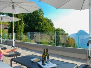 een patio met 2 tafels met wijnflessen erop bij Apartment Aldesago Monte Brè - Utoring-28 by Interhome in Viganello