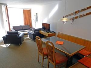 salon ze stołem, krzesłami i kanapą w obiekcie Apartment Parkareal - Utoring-49 by Interhome w Davos