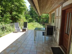 un patio con sedie e un tavolo sul balcone. di Holiday Home Leubach by Interhome a Schiltach