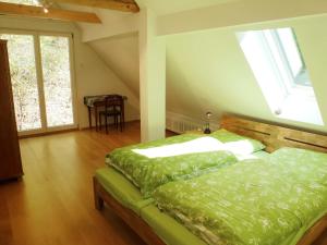 una camera con letto e piumone verde di Holiday Home Leubach by Interhome a Schiltach