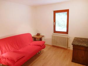 ein Wohnzimmer mit einem roten Sofa und einem Fenster in der Unterkunft Holiday Home Leubach by Interhome in Schiltach