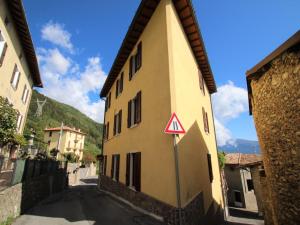a yellow building with a yield sign on a street at Apartment Formaga-2 by Interhome in Gargnano
