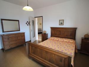 sypialnia z dużym drewnianym łóżkiem i komodą w obiekcie Apartment Formaga-2 by Interhome w mieście Gargnano +14 zdjęć