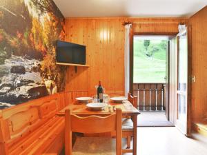 ein Esszimmer mit einem Tisch und einem TV an der Wand in der Unterkunft Apartment Penia 2-1 by Interhome in Penia