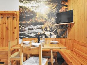 a dining room with a wooden table and a tv at Apartment Penia 2-1 by Interhome in Penia