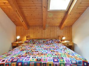 a bedroom with a bed with a colorful quilt at Apartment Penia 2-1 by Interhome in Penia +30 photos