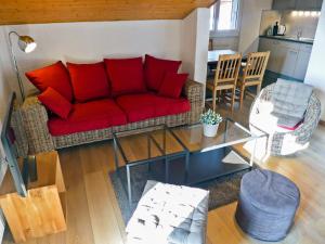 a living room with a red couch and a table at Apartment Les Bruyères 25 by Interhome in Chesières