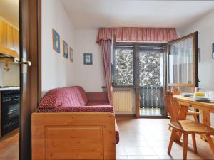 sypialnia z łóżkiem, stołem i oknem w obiekcie Apartment Des Alpes-3 by Interhome w mieście Canazei