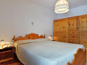 sypialnia z dużym łóżkiem i drewnianymi szafkami w obiekcie Apartment Des Alpes-3 by Interhome w mieście Canazei