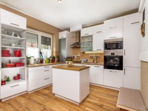バラトンマーリアフュルドゥーにあるHoliday Home Colore by Interhomeの白いキャビネット付きのウッドフロアのキッチン