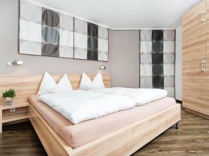a bedroom with a large bed with white sheets at Apartment Am Bärenkopf-1 by Interhome in Maurach
