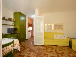 een woonkamer met een gele bank en een keuken bij Apartment Capo d'Arco-3 by Interhome in Capo D'Arco