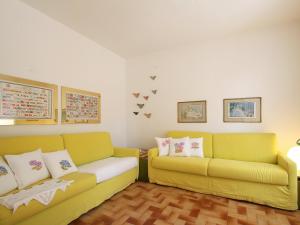 een woonkamer met twee gele banken bij Apartment Capo d'Arco-3 by Interhome in Capo D'Arco