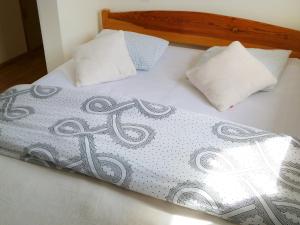 a bed with a cross on it with two pillows at Holiday Home Domek Joanna-1 by Interhome in Łeba