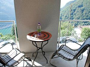 una mesa con una botella y 2 sillas en el balcón en Apartment Allaventura by Interhome, en Mergoscia