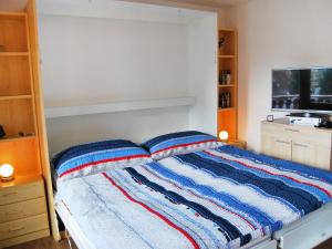 ナンダにあるApartment Ambassador II Apt 13 by Interhomeのベッドルーム1室(カラフルなストライプ毛布付きのベッド1台付)