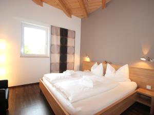 a large white bed in a room with a window at Apartment Am Bärenkopf-4 by Interhome in Maurach