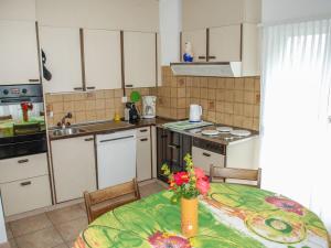 a kitchen with a table with a vase of flowers on it at Apartment Gemma by Interhome in Chironico
