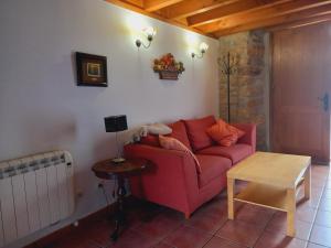 a living room with a red couch and a table at Errotazar apartamento rural P in Alsasua