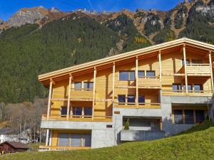 a building on a hill with mountains in the background at Apartment Bab Port Apt- 03 by Interhome in Wengen